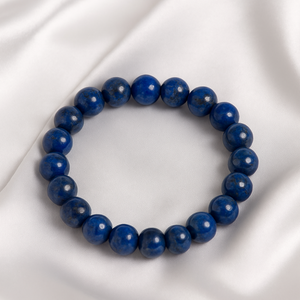 Blue beaded bracelet on a white satin background