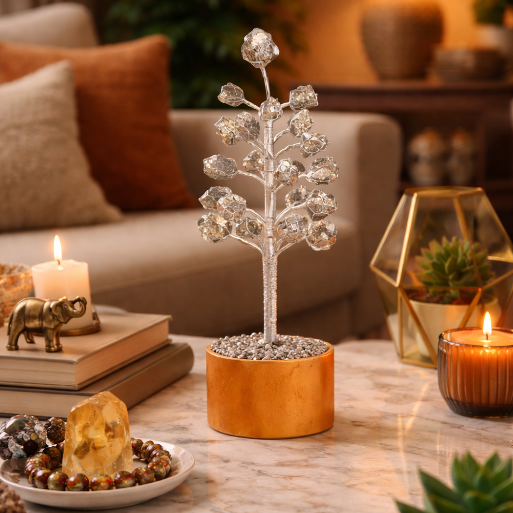 Decorative pyrite tree on a marble table with candles and books in a cozy living room.