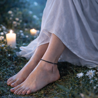 Person in a white dress wearing a Black tourmaline anklet