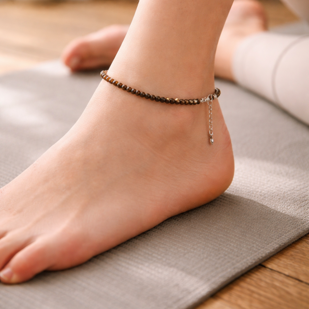 Person's foot wearing a tiger eye beaded anklet on a yoga mat  for protection, confidence and clarity