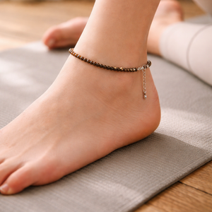 Person's foot wearing a tiger eye beaded anklet on a yoga mat  for protection, confidence and clarity